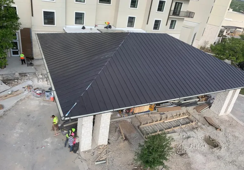 Metal roofing installation team working on a commercial building in Indian Hills